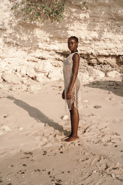 Binar Dress in Ivory - sleeveless fishnet crochet mini with dramatic fringe hem, side view | NYALA