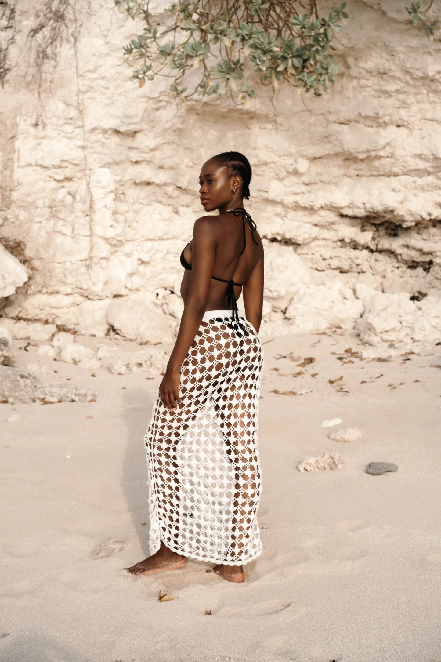 Daisy Skirt in Ivory - fitted body-con open-weave crochet maxi with knit waistband and front center slit, side view | NYALA