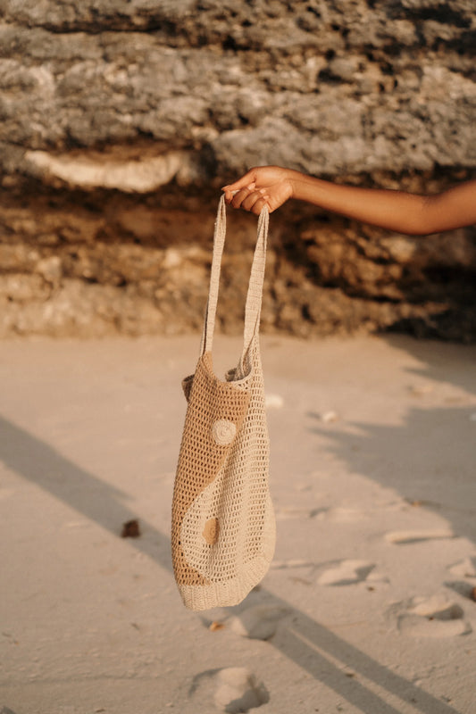Terra Tote Bag in Cream - large open-weave crochet tote with yin and yang medallion detail, front lifestyle view | NYALA